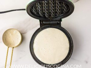 A waffle being cooked in a waffle maker